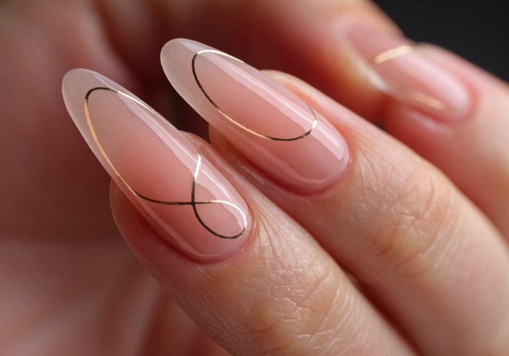 Gold line art and negative space nail design on almond nails