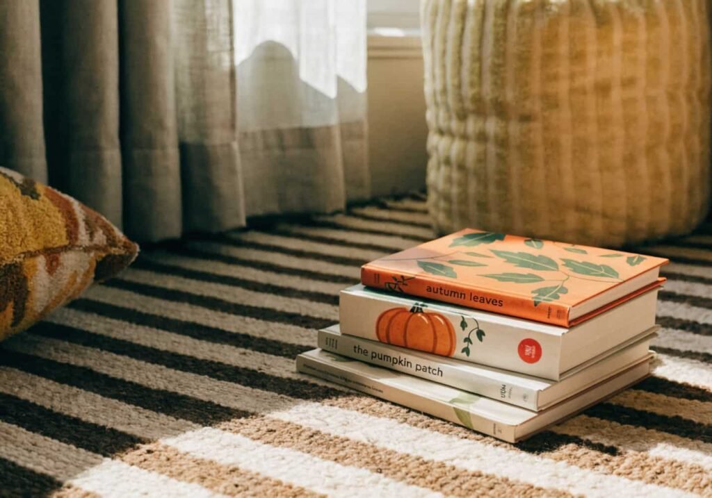 Stack of fall-themed picture books in a kindergarten reading corner
