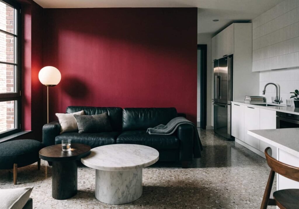 Burgundy accent wall defining a living room in an open-plan apartment