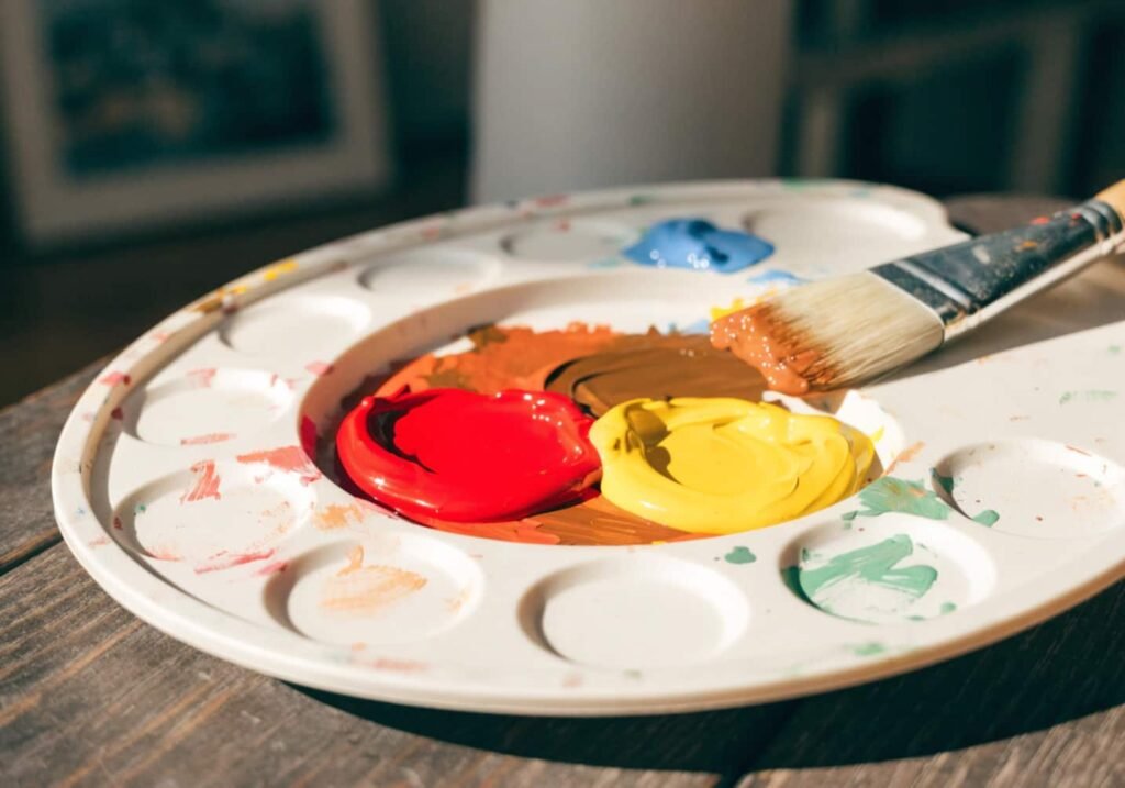 Paint palette showing primary colors mixed into fall orange and brown shades.