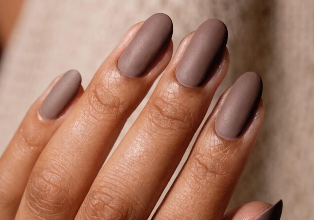 Matte finish luxury nails in deep taupe shade close-up