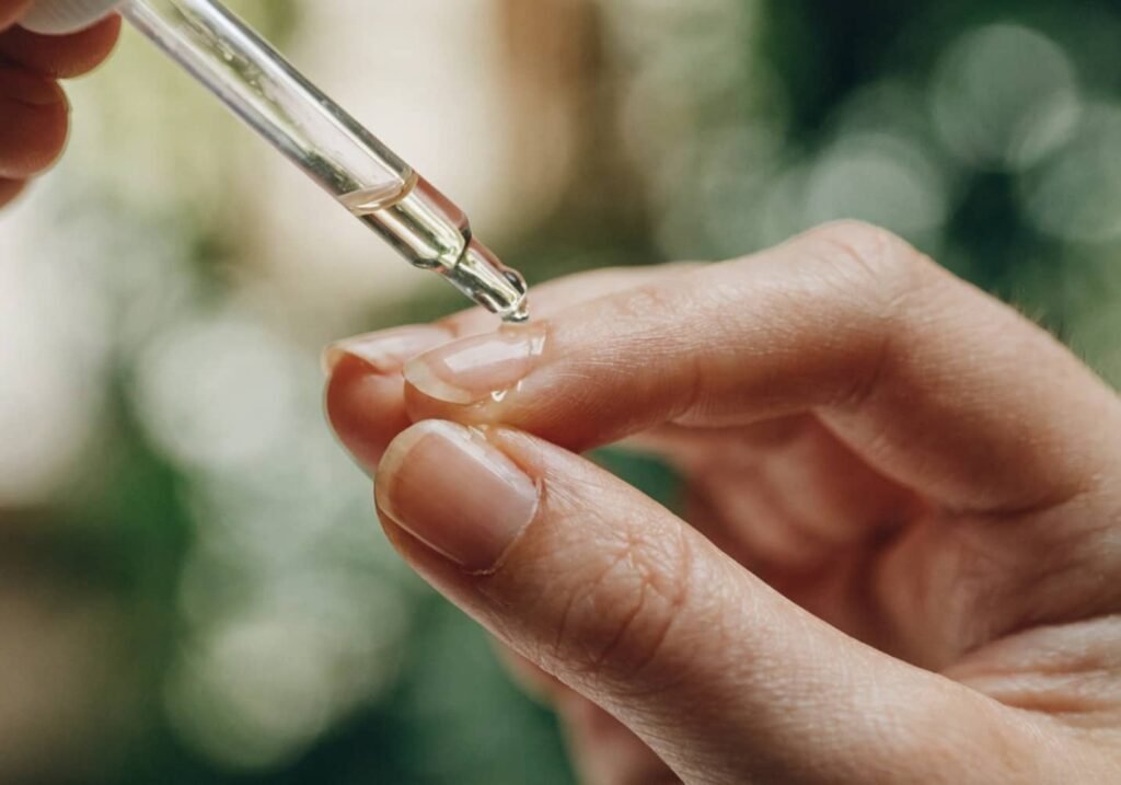 Applying cuticle oil as part of a nightly nail care routine for healthy, elegant nails.
