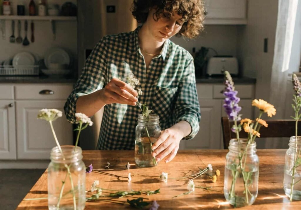 DIY flower centerpiece preparation for a budget-friendly backyard wedding.