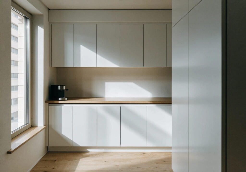 Minimalist modern kitchen with handleless cabinetry and a clutter-free countertop.