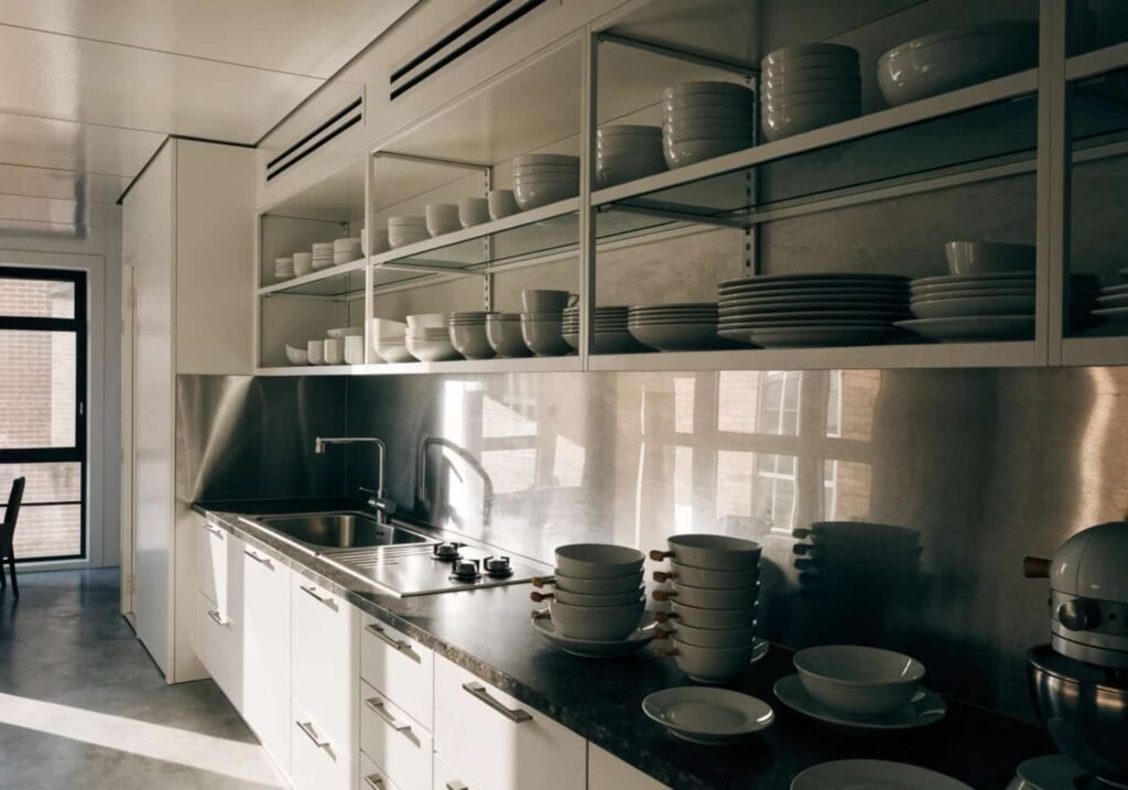 Small kitchen made to look bigger with open shelving and a reflective backsplash