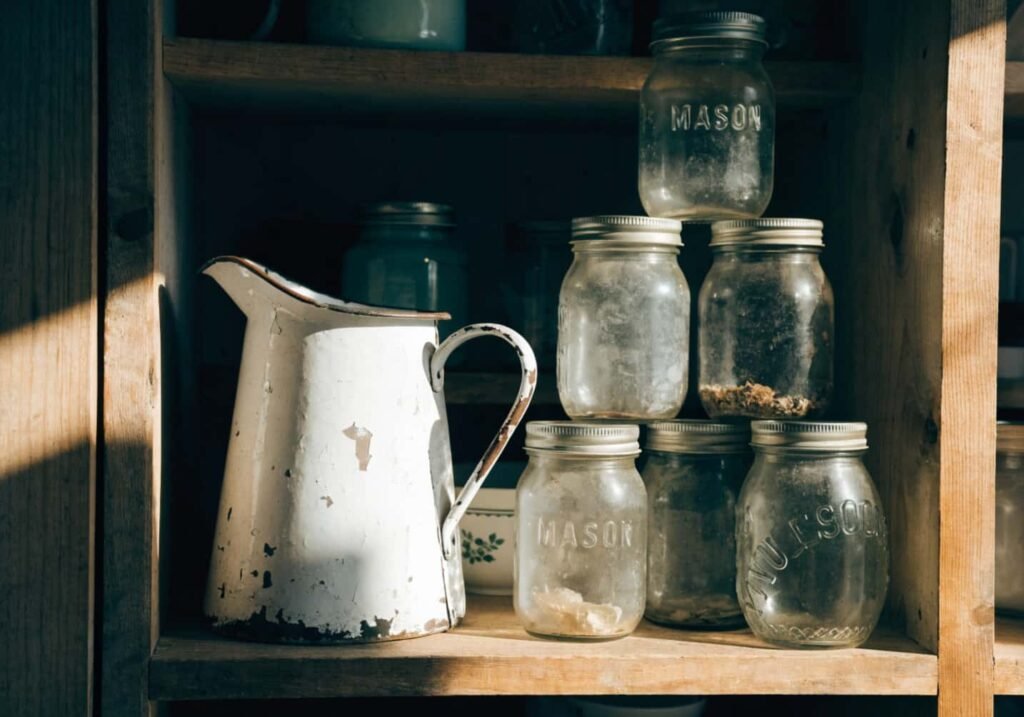 Vintage enamelware and mason jars styled on a farmhouse kitchen shelf