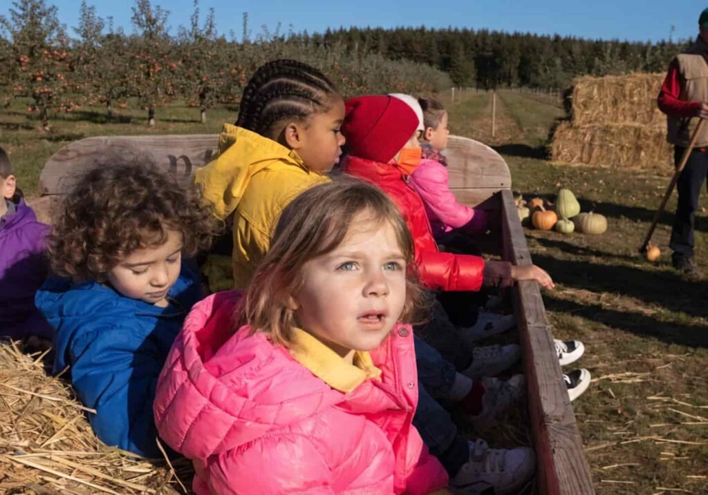 Kindergarten class on a hayride field trip at an apple orchard in fall