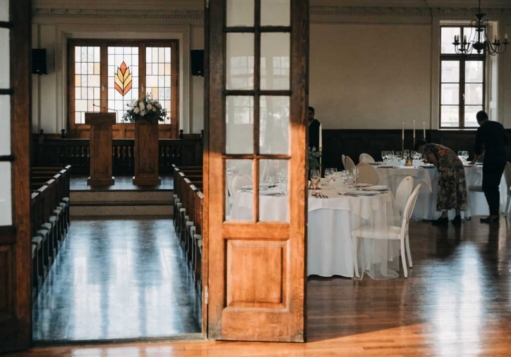 Indoor wedding reception room set up and visible from ceremony space