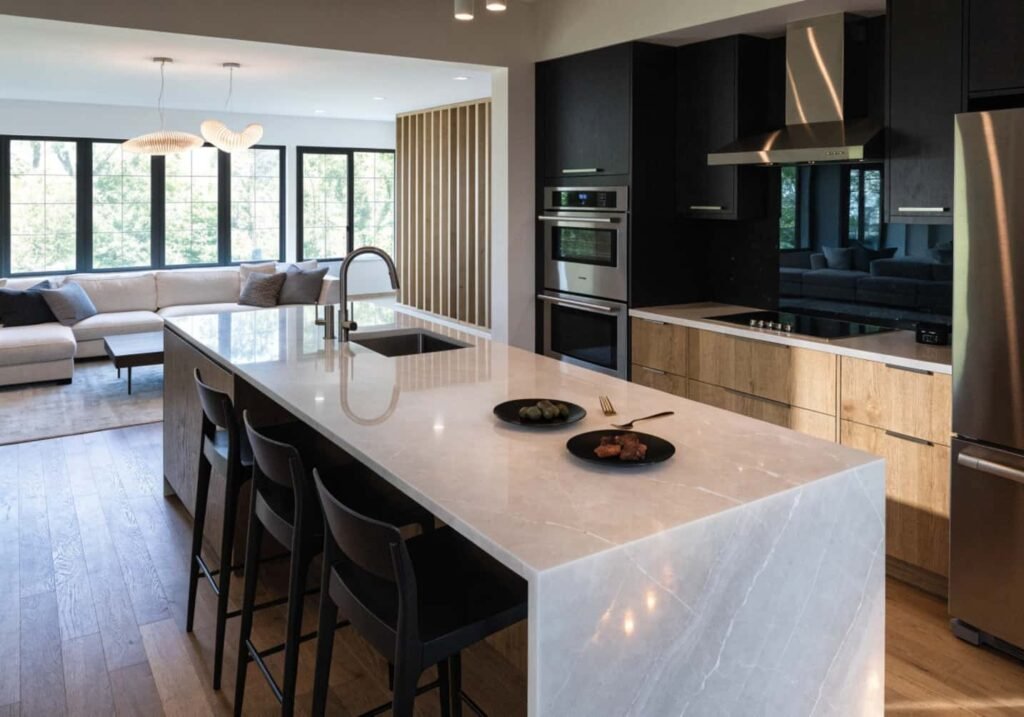 Open concept kitchen with waterfall island connecting to a modern living room.