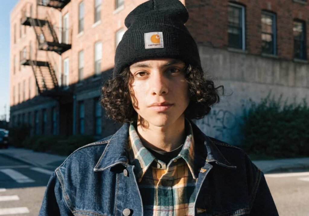 Styled outfit featuring a cuffed Carhartt beanie with flannel and denim