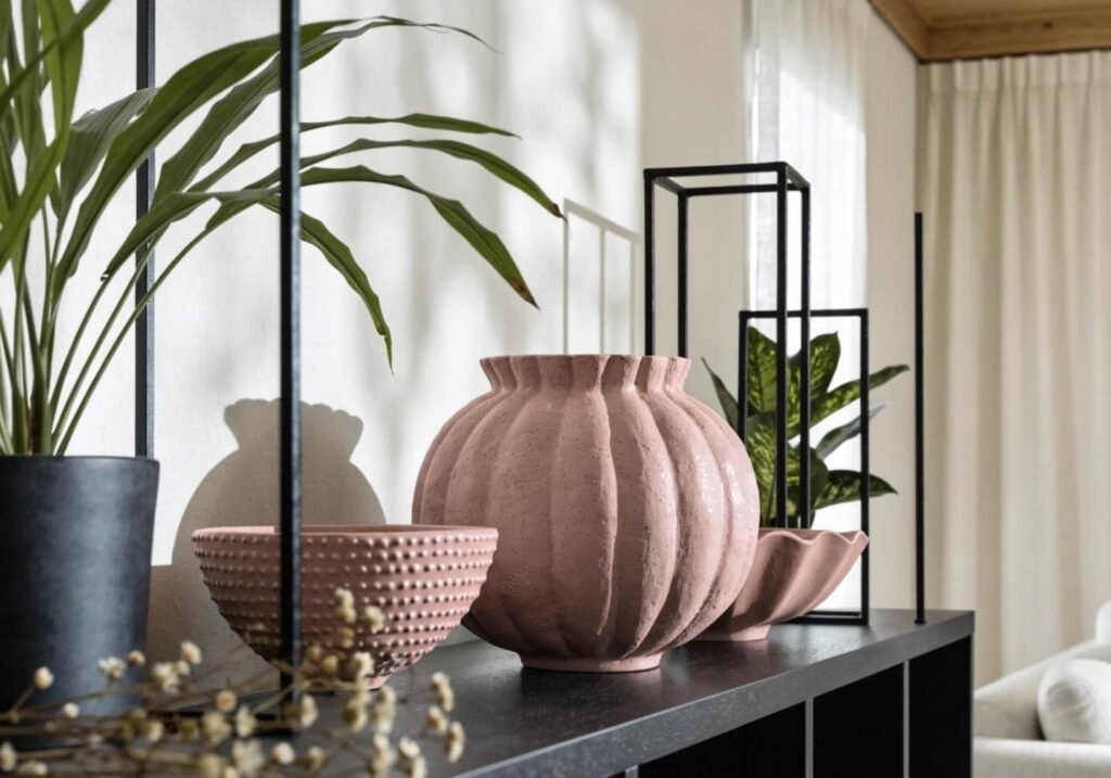 Floor-length blush pink linen curtains in a sunlit living room, fabric slightly billowing near an open window.