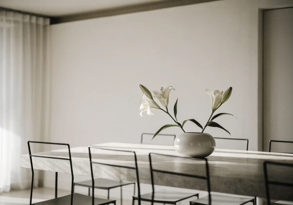 Low lily centerpiece styled on a modern dining table in a neutral interior