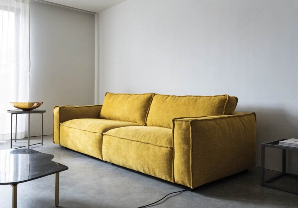 Bold mustard yellow textured sofa standing out in a modern living room