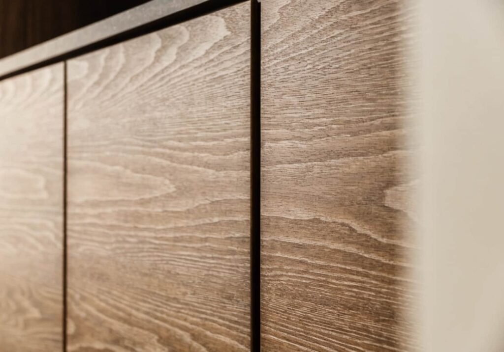 Sleek flat-panel kitchen cabinets with seamless grain-matched wood veneer.