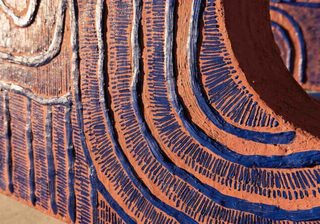 Close-up of warm terracotta and indigo tones in textured Afrohemian wall art