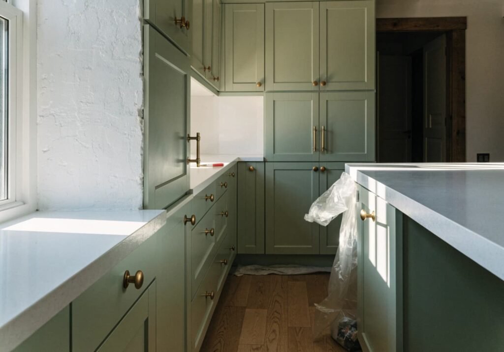 Kitchen cabinets repainted sage green as a low-cost room refresh