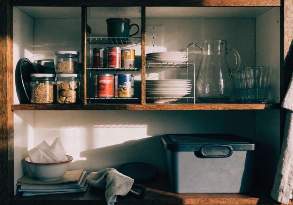 Stackable shelf risers holding canned goods in a kitchen cabinet