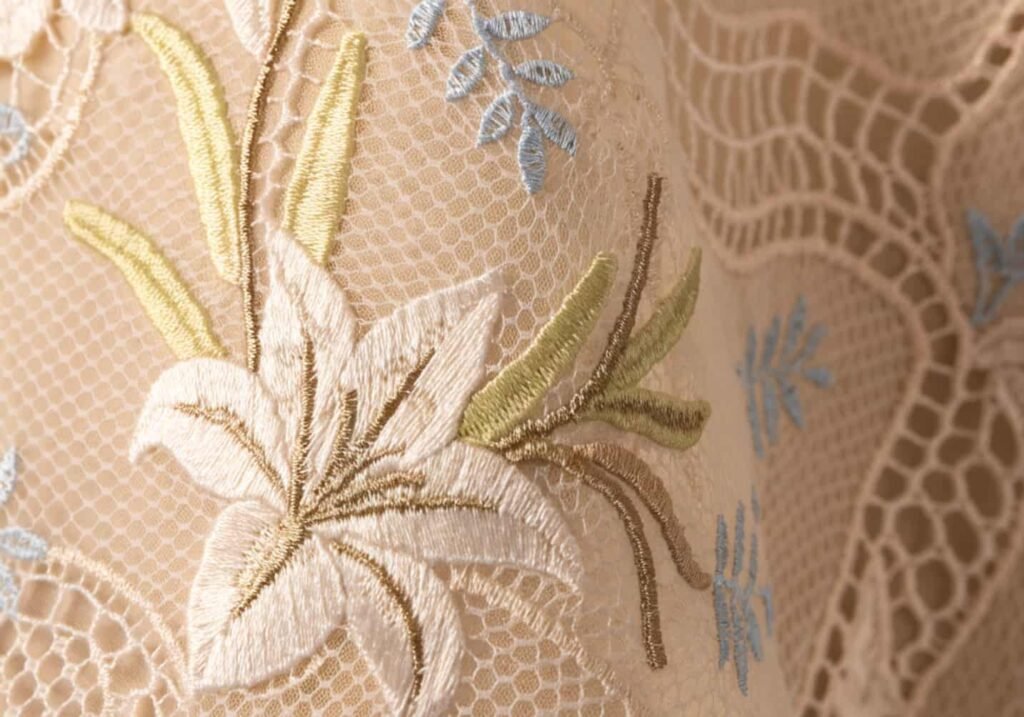 Close-up of lace fabric embroidered with a trumpet lily motif