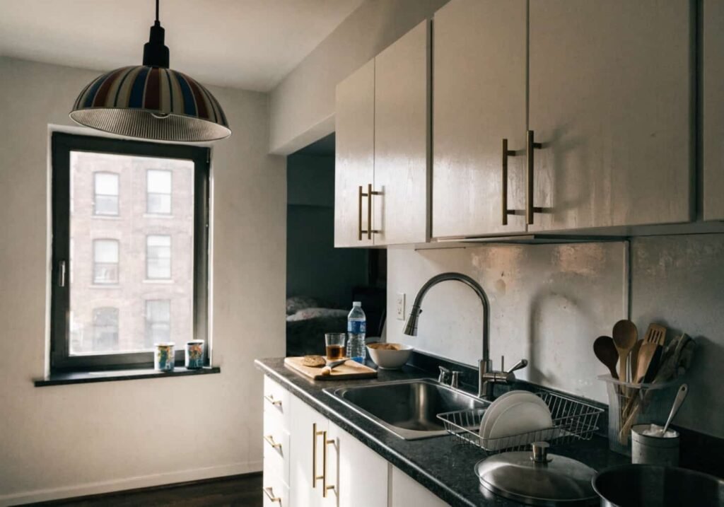 Small apartment kitchen with Neo Art Deco brass accents and pendant lighting