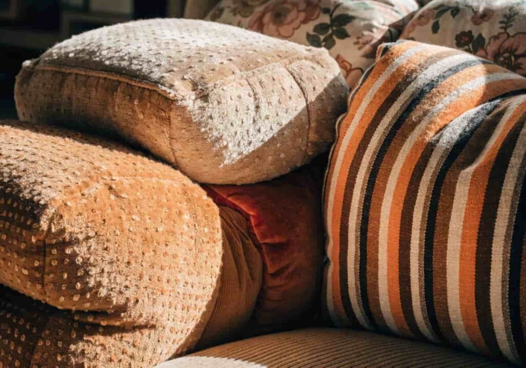 Plump overstuffed cushions in warm tones on a sofa