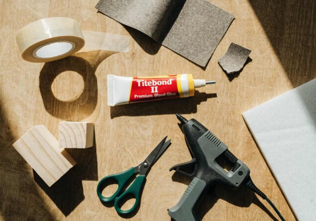 Beginner DIY decor toolkit flat lay with tape, glue, and sandpaper
