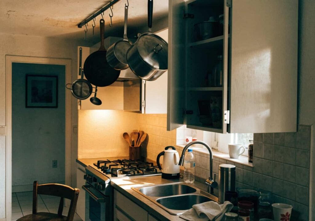Pots and pans hanging from a ceiling rail in a kitchen