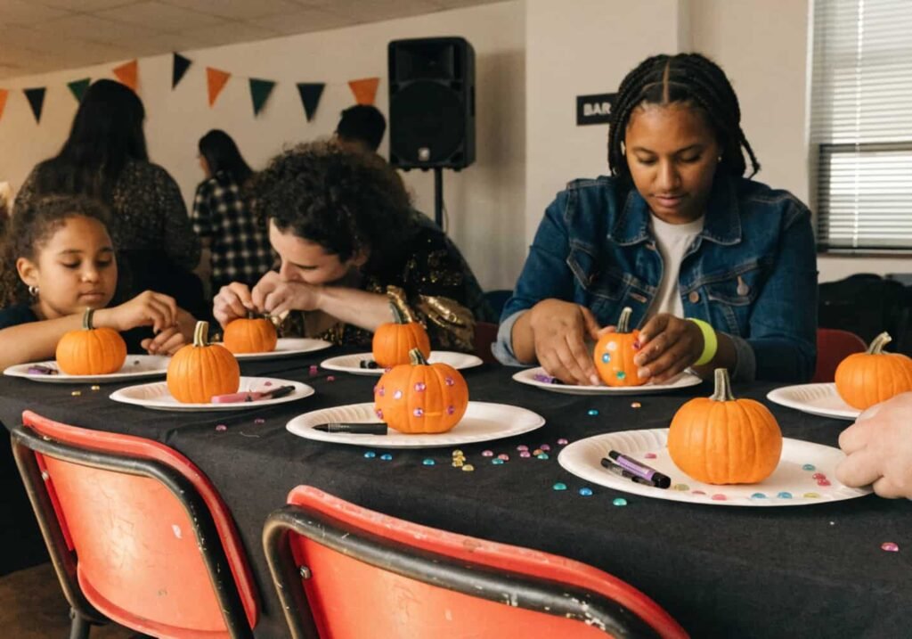 Halloween party craft station with mini pumpkins and decorating supplies for guests.