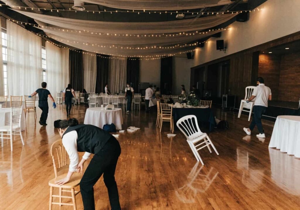 Staff performing a quick room changeover between ceremony and reception indoors.