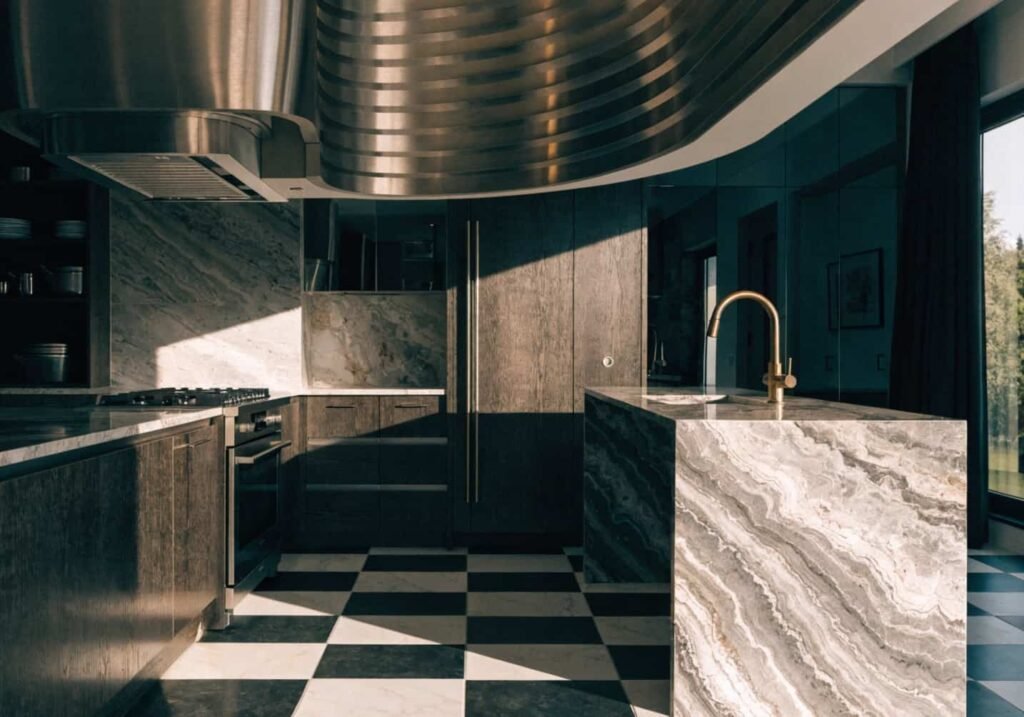 Curved range hood and checkerboard floor as statement pieces in Neo Art Deco kitchen