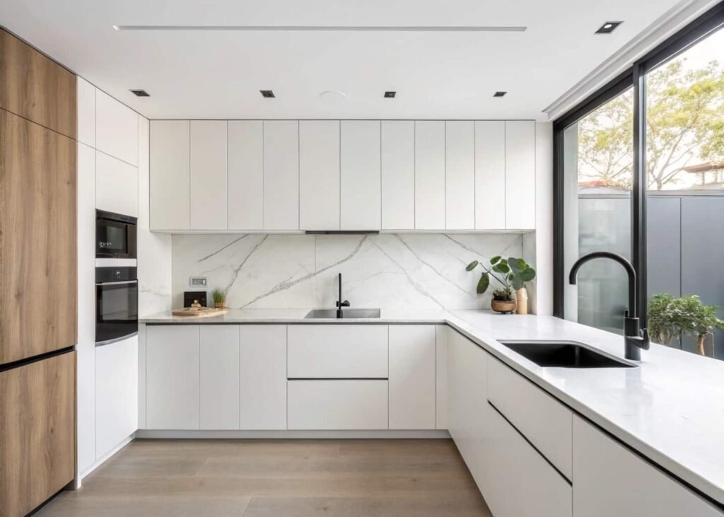 Modern minimalist kitchen with slab cabinets and matching quartz backsplash