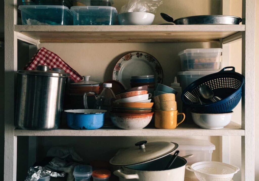 Example of a cluttered open shelf mistake to avoid in kitchen design.