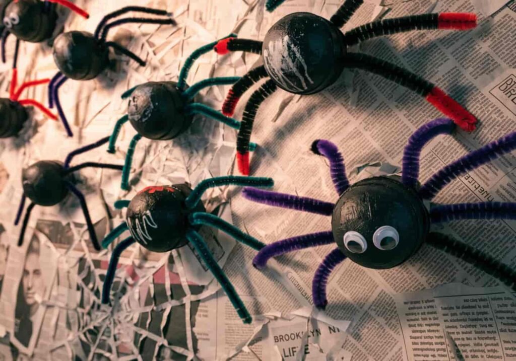 DIY recycled spiders made from egg cartons decorating a Halloween bulletin board.