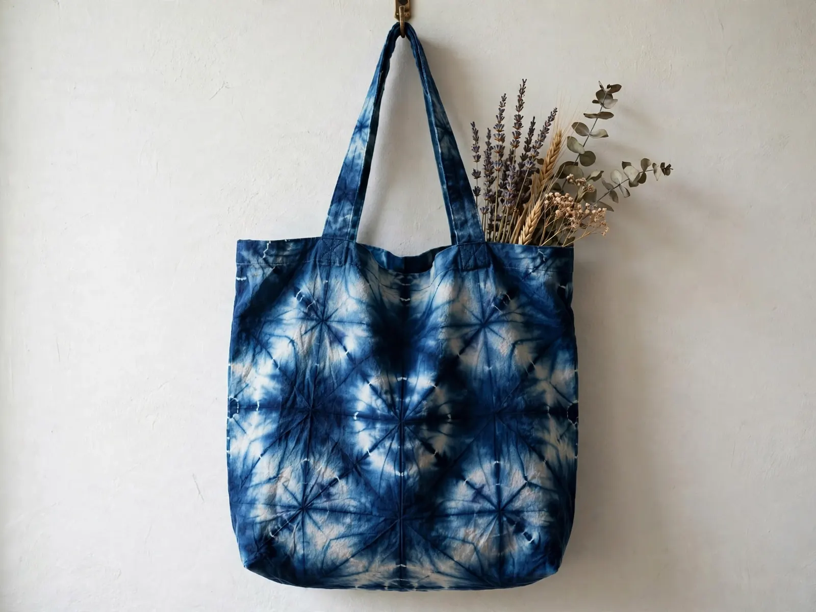 Indigo shibori-dyed canvas tote bag with dried flowers