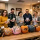 Coworkers voting beside decorated pumpkins in a break room