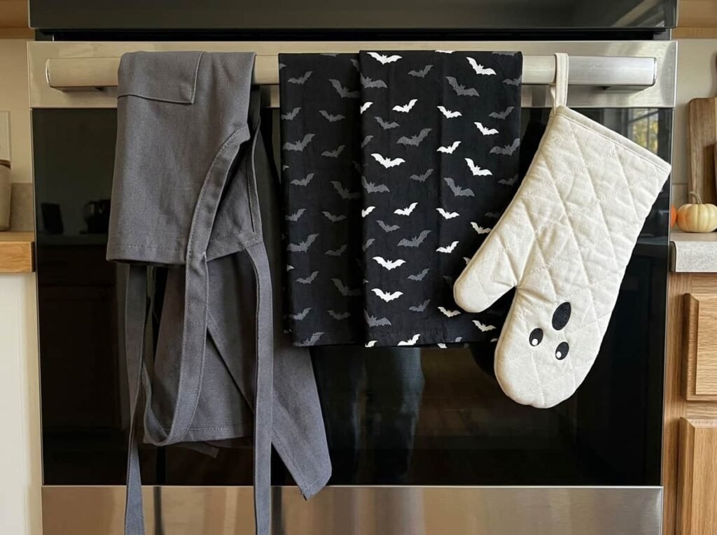 Halloween dish towels, oven mitts and apron in a kitchen