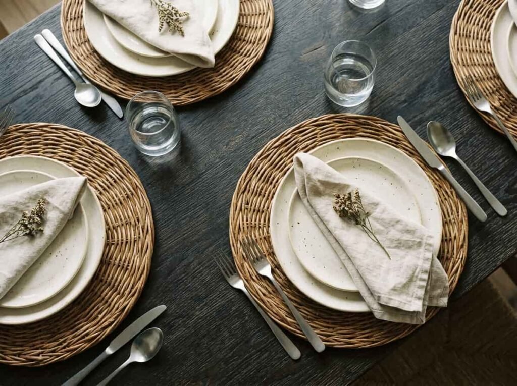Woven rattan placemats with plates and napkins on a Thanksgiving dining table