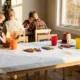 Kids Thanksgiving table covered in draw-on paper with crayons and paper hats at every seat